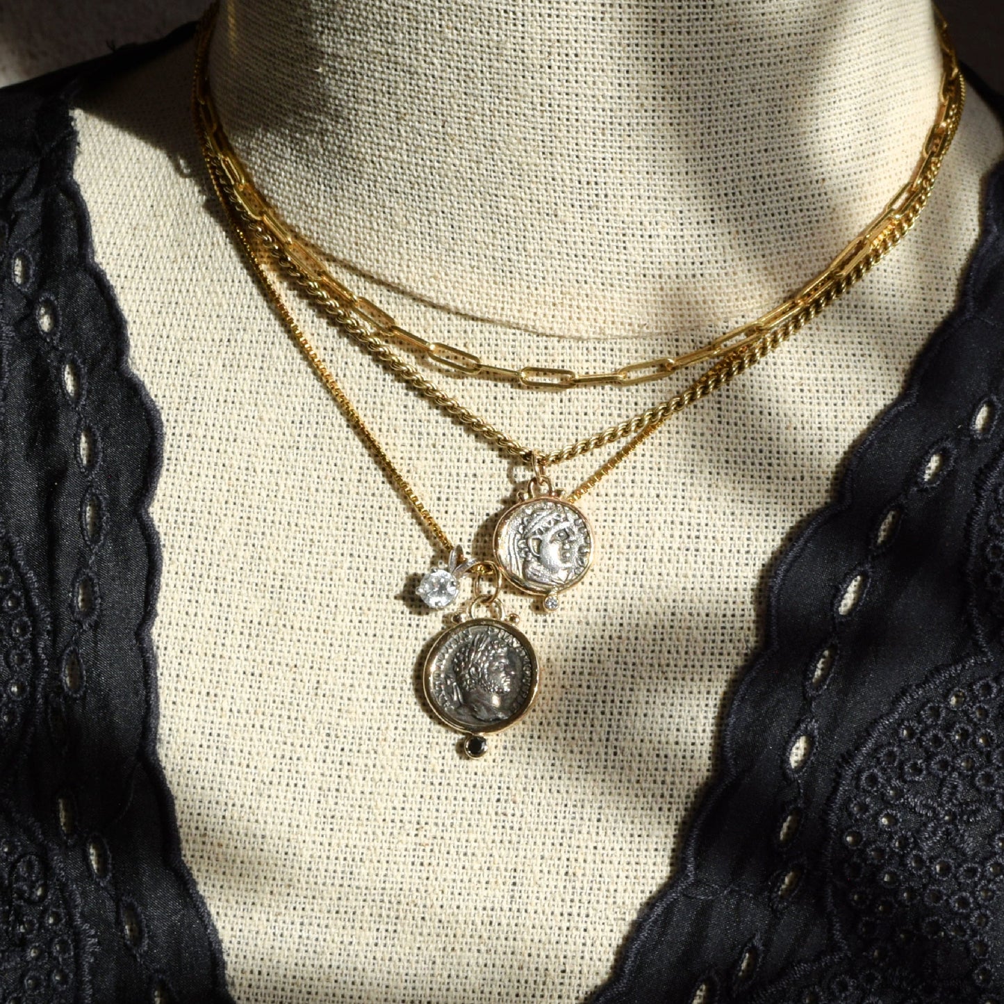 Ancient coin and diamond necklaces layered with gold chains