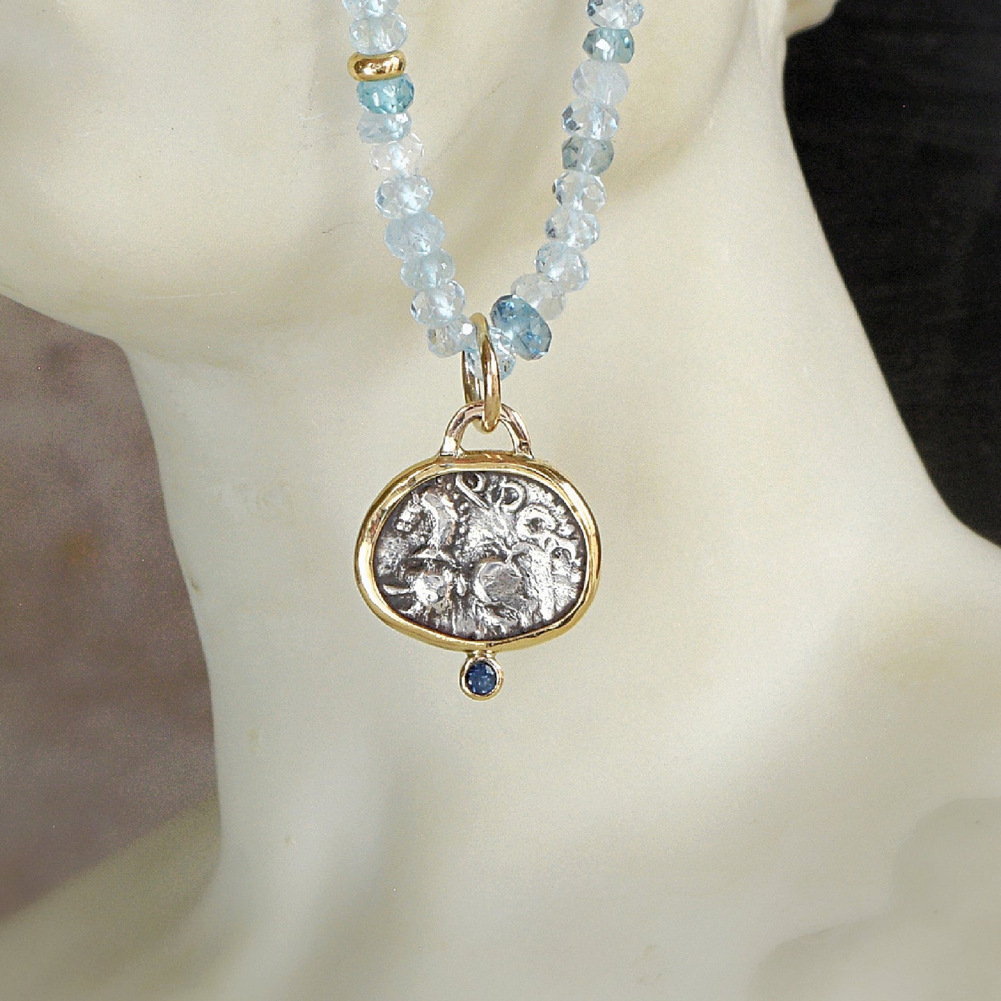 Ancient Celtic coin pendant with blue sapphire hanging on Aquamarine bead necklace with gold