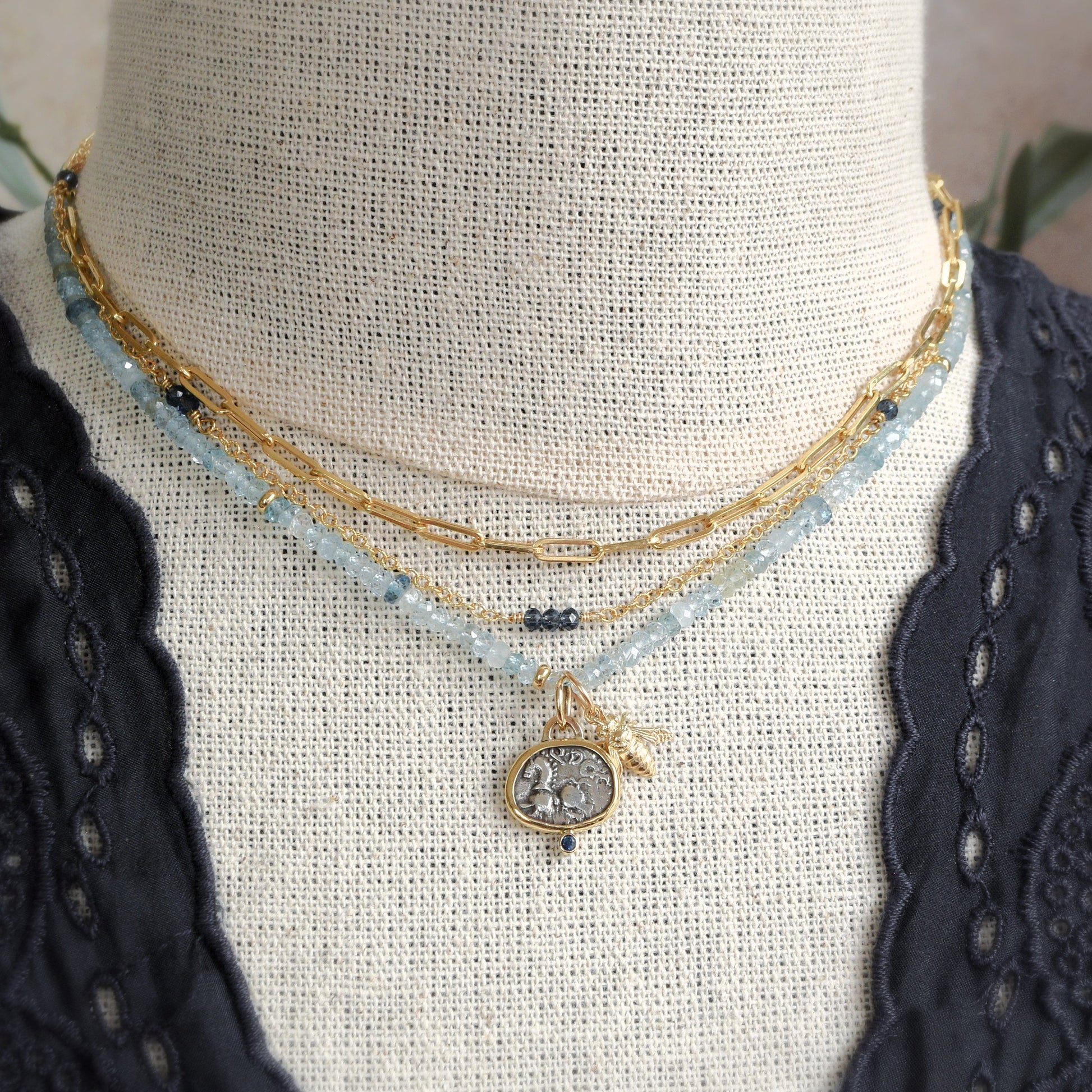 Ancient coin necklace with horse and blue sapphire; gold with honeybee charm